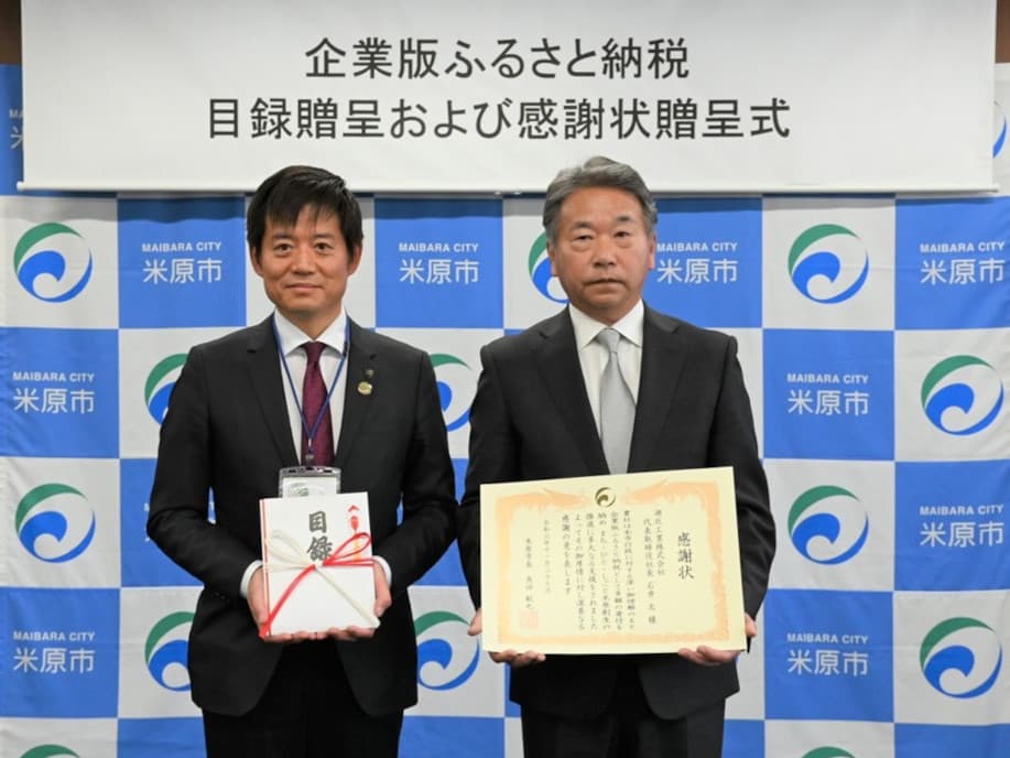 米原市役所で行われた「企業版ふるさと納税目録贈呈および感謝状贈呈式」の様子。左は角田航也米原市長。右は湖北工業代表取締役社長石井太。